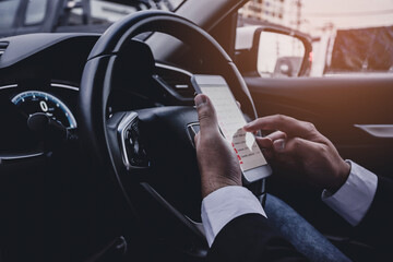 hands of businessmen using a smartphone while driving Safety driving concept