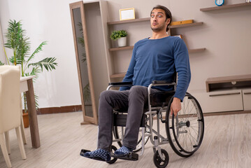 Young man in wheel-chair suffering at home