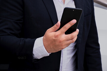 Closeup hand of Businessman wearing suits holding mobile phones, business concept