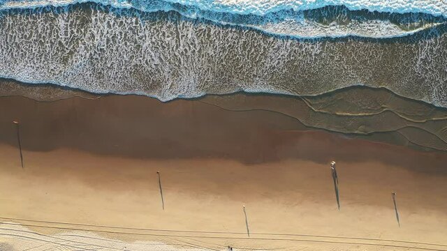 Aerial top down view over beach with ocean waves. Gold Coast, Australia