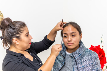 woman dressed in black blouse putting makeup on another younger woman