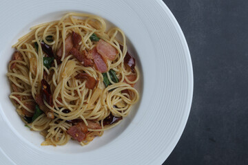 Stir-fried Spaghetti with dried chili and crispy bacon. Top view