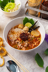 Spicy tom yam noodle soup with pork and meatball