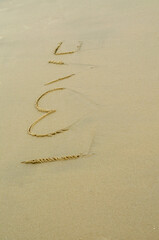 love text fade away on sand by sea wave