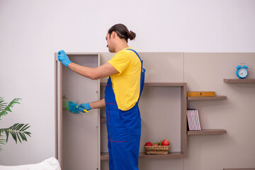 Young male contractor cleaning the house