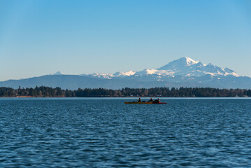 Kayakers paddling in Birch Bay in the late afternoon light, peaceful scenic landscape
