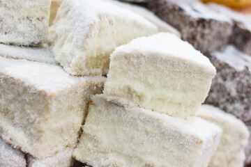 Pieces of fresh baked cake with icing and desiccated coconut