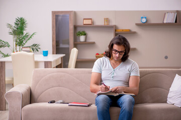 Obraz premium Young male student preparing for exams at home