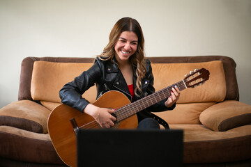 Young woman takes online classes to learn to play acoustic guitar