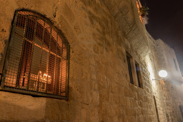 A menorah is lit inside a window, in an ancient house in the Jewish Quarter of the Old City of Jerusalem