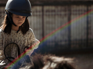 Asian school kid girl with horse ,riding or practicing horse ridding at horse ranch.