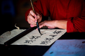 Close up on hand holding brush while writing calligraphy in Hanoi, Vietnam.