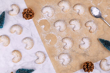 Traditional crescent shaped christmas cookies called 'Vanillekipferl', a traditional Austrian or German Christmas biscuits with nuts and icing sugar surrounded by Christmas decoration