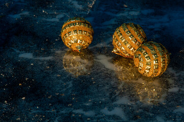Golden balls on ice. Merry Christmas and happy New year. Christmas background with Christmas decorations. Christmas card. 