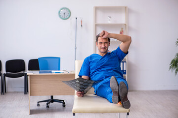 Young male doctor radiologist being unhappy after night shift