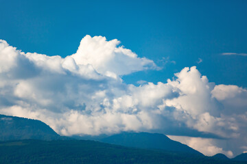 Obraz premium White clouds in blue sky wrapped up mountain peaks with blurry background, used as a background or texture, soft focus