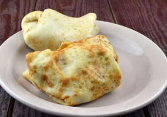 
pancakes with different fillings are in a plate on the kitchen table