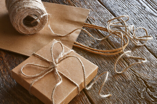 A close up image of a vintage style  brown paper bag and box tied with burlap thread. 
