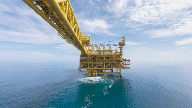4K time lapse of yellow processing platform of oil and gas in the middle of South China sea with blue sky and thick clouds movement.