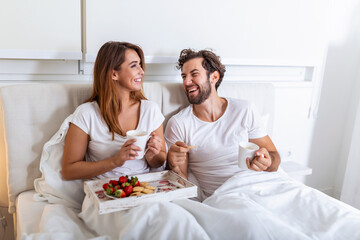 Young married couple in love eating breakfast in their bed. Good morning! Healthy breakfast in bed....