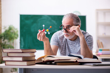 Old male physicist student in the classroom