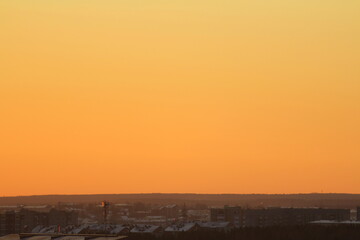 Sun below the horizon and clouds in the fiery dramatic orange sky at sunset or dawn backlit by the sun. Place for text and design
