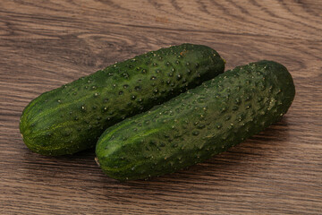 Green fresh cucumbers over background
