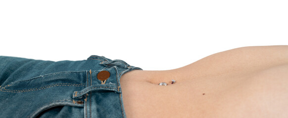 Belly button or navel piercing, of young woman wearing jeans isolated on white.