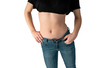 Belly button or navel piercing, of young woman wearing jeans isolated on white.