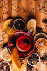 Fototapeta na wymiar Christmas mulled wine, Drink with dried fruits and berries, Winter hot tea in a glass and spices on a wooden background.