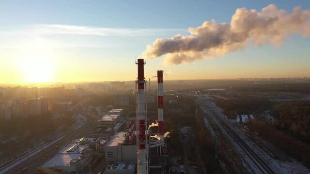 Aerial shot of red and white industrial smoke stacks on sunset background. Moscow, Russia
