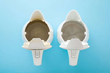 New and old kettles on light blue table background. Pastel color. Compare two objects with and...