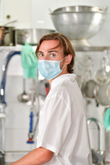 Fototapeta na wymiar view of a young male chef using a surgical mask looking at the camera