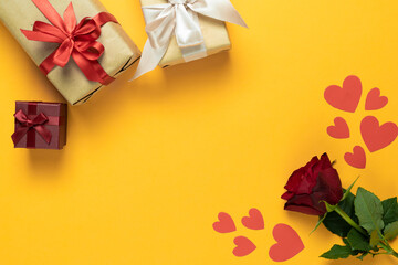 red rose on a yellow background, several beautiful wrapped boxes. Place for your text. Background for lovers