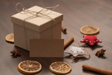 Christmas gift box from eco friendly paper wrapped with natural twine on wood table with natural decorations and greeting card