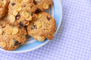 Group of cereal cookies in plate on table with tablecloth. Freshly baked oats biscuits.