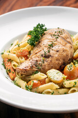 fried chicken breast with penne and saute vegetables pasta dish