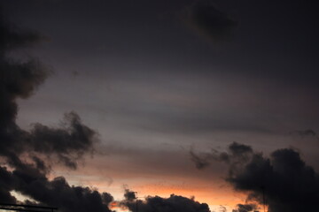 Fototapeta na wymiar Atardecer anaranjado con nubes grises y pájaros volando (Madrid)