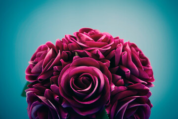 Bouquet of artificial roses on blue background