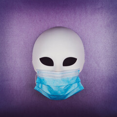 Carnival mask with protective face mask on purple background. Corona virus pandemic concept.
