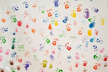 Background of many colorful hand prints on a wall. Childhood concept