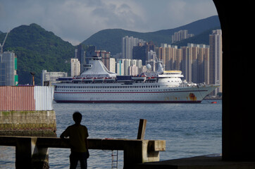 Luxury cruiseship or cruise ship liner with Hongkong Central skyline in Victoria Harbor with Hong...