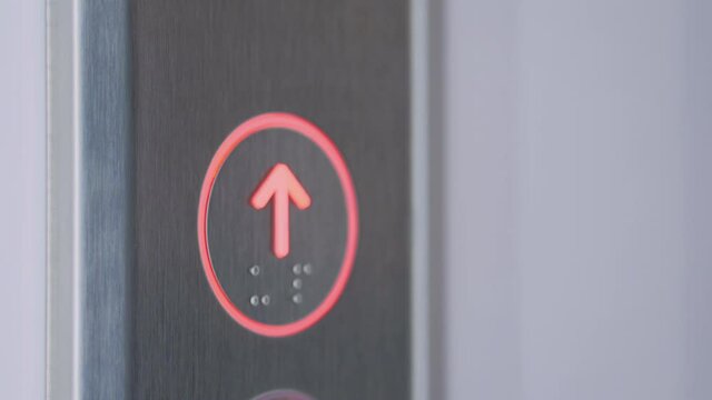 Woman finger pressing elevator up button on lift control panel at mall, hotel or business center - close up view, slow motion. Technology, moving up, progress, growth and success concept