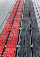 Cable tray with red and black solar cables in it for solar power plant installation