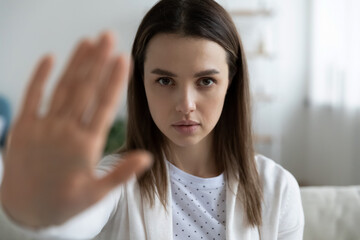 Head shot portrait close up confident woman showing stop or defense gesture, serious focused girl...
