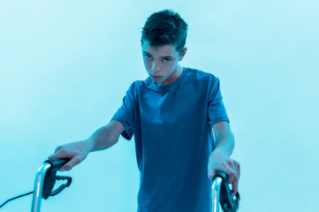 Portrait of teenaged disabled boy with cerebral palsy looking at camera, taking steps with his...