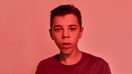 Close up portrait of teenaged disabled boy with cerebral palsy looking away, posing isolated over...