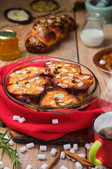 Freshly baked bread pudding with raisins, almond flakes and cardamom in a baking dish on the table. Dessert concept, close-up. Tea dissert concept