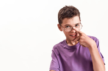 Portrait of teenaged disabled boy with cerebral palsy smiling at camera, adjusting his glasses isolated over white background