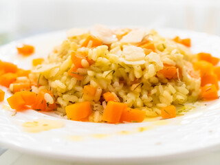 Risotto with carrot and parmesan on white background